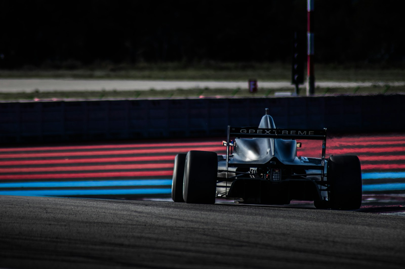 Open-wheel race car on track at dusk